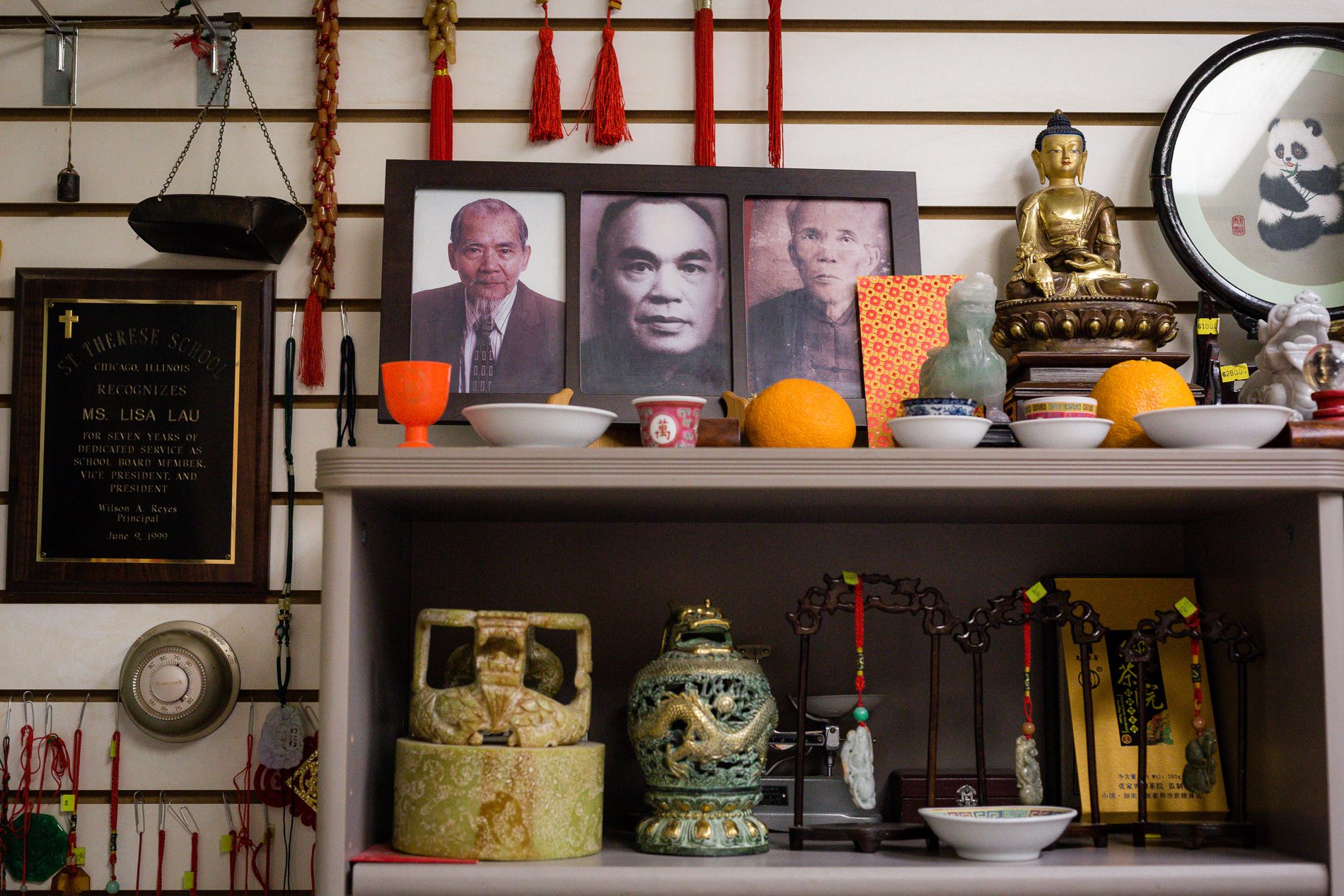 Three photos at the top of shelf showing Lisa Lau’s father, grandfather and great-grandfather
