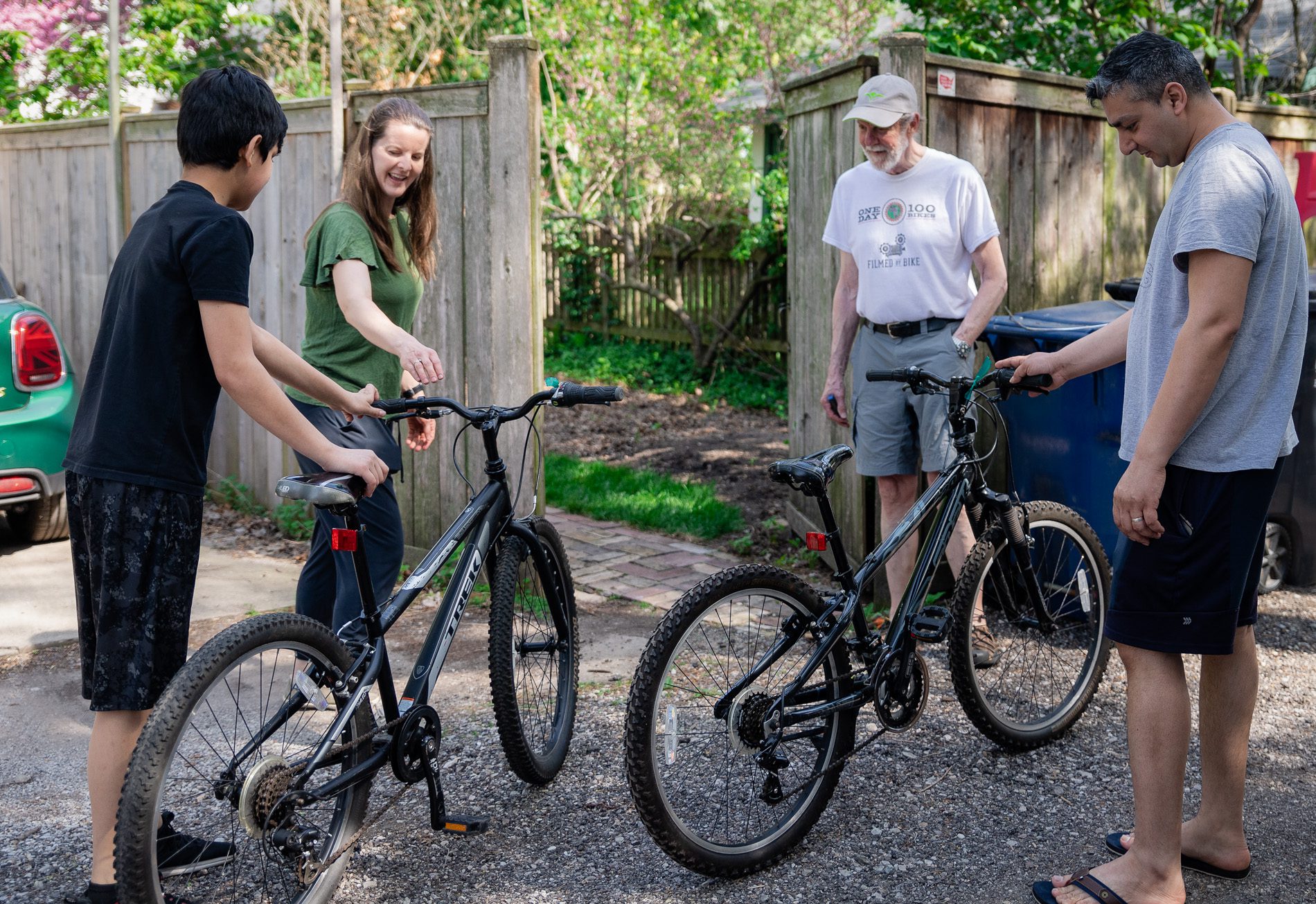 Natalie Moore Topinka and her father, Scott Moore, center, show Yahya Nazari, left, and Nazari’s uncle Mohammad Aimal, right, another bike after his first test ride