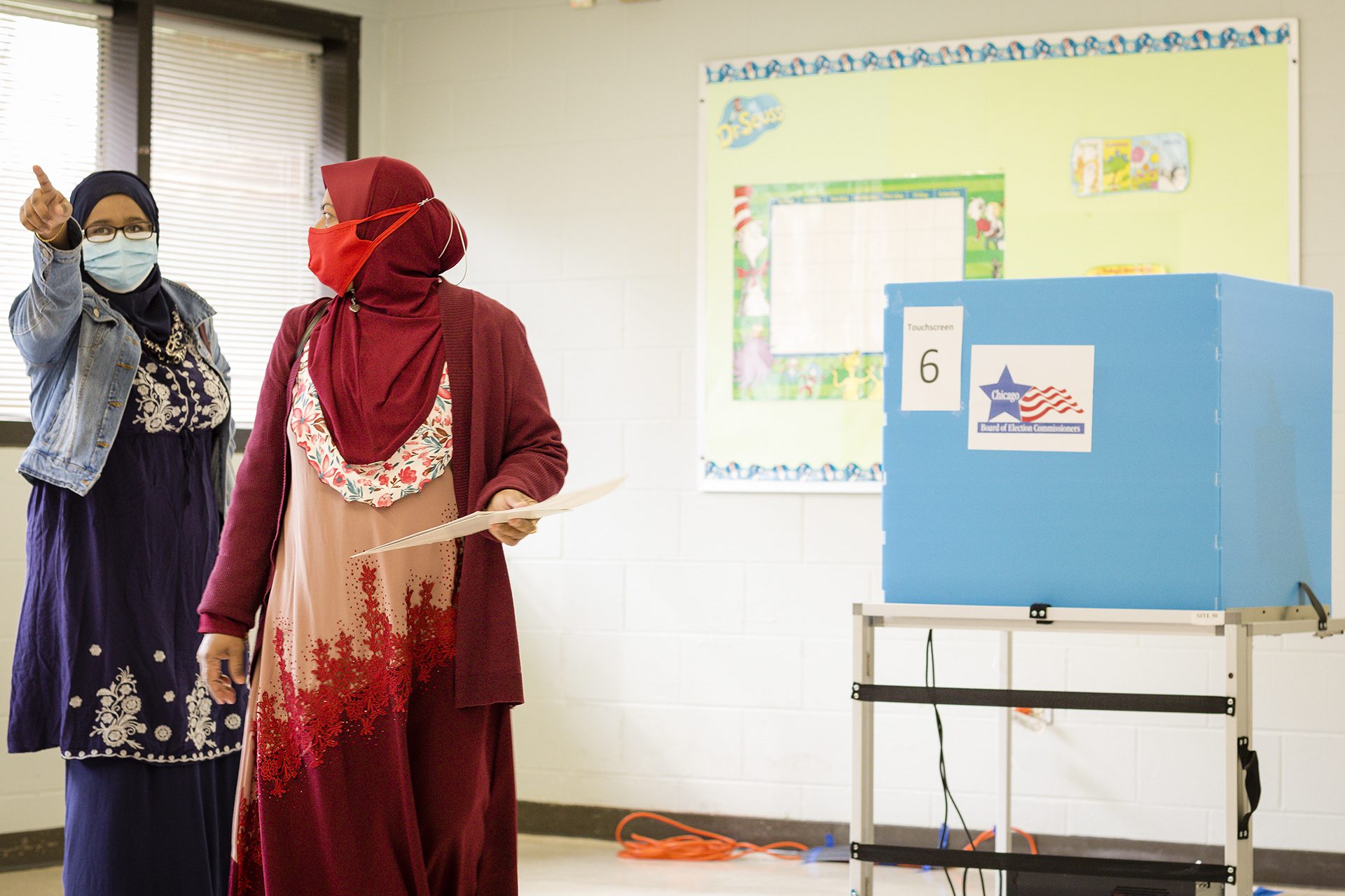 A woman in a red hijab votes