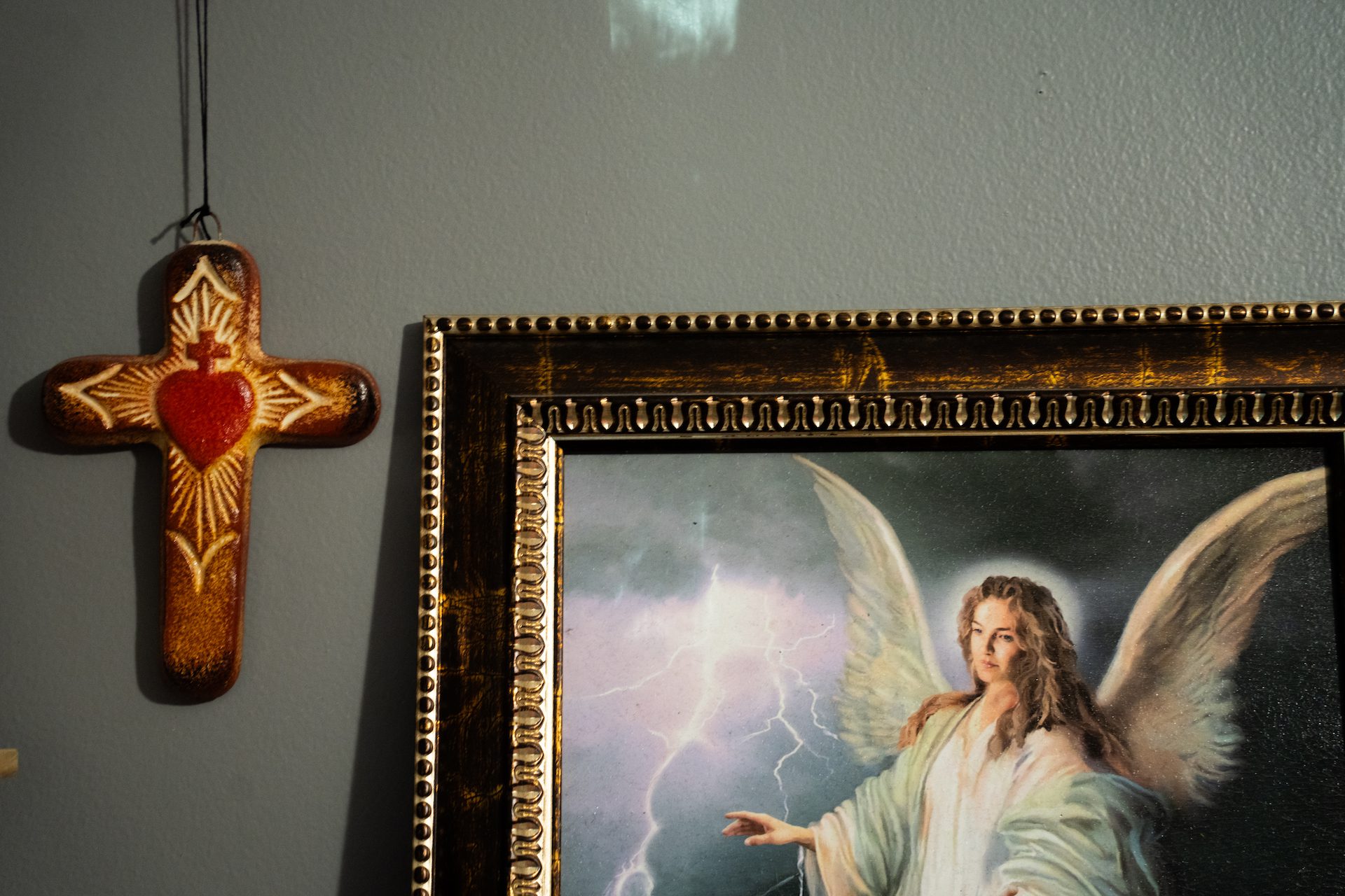 A cross and religious painting in Ada's home.