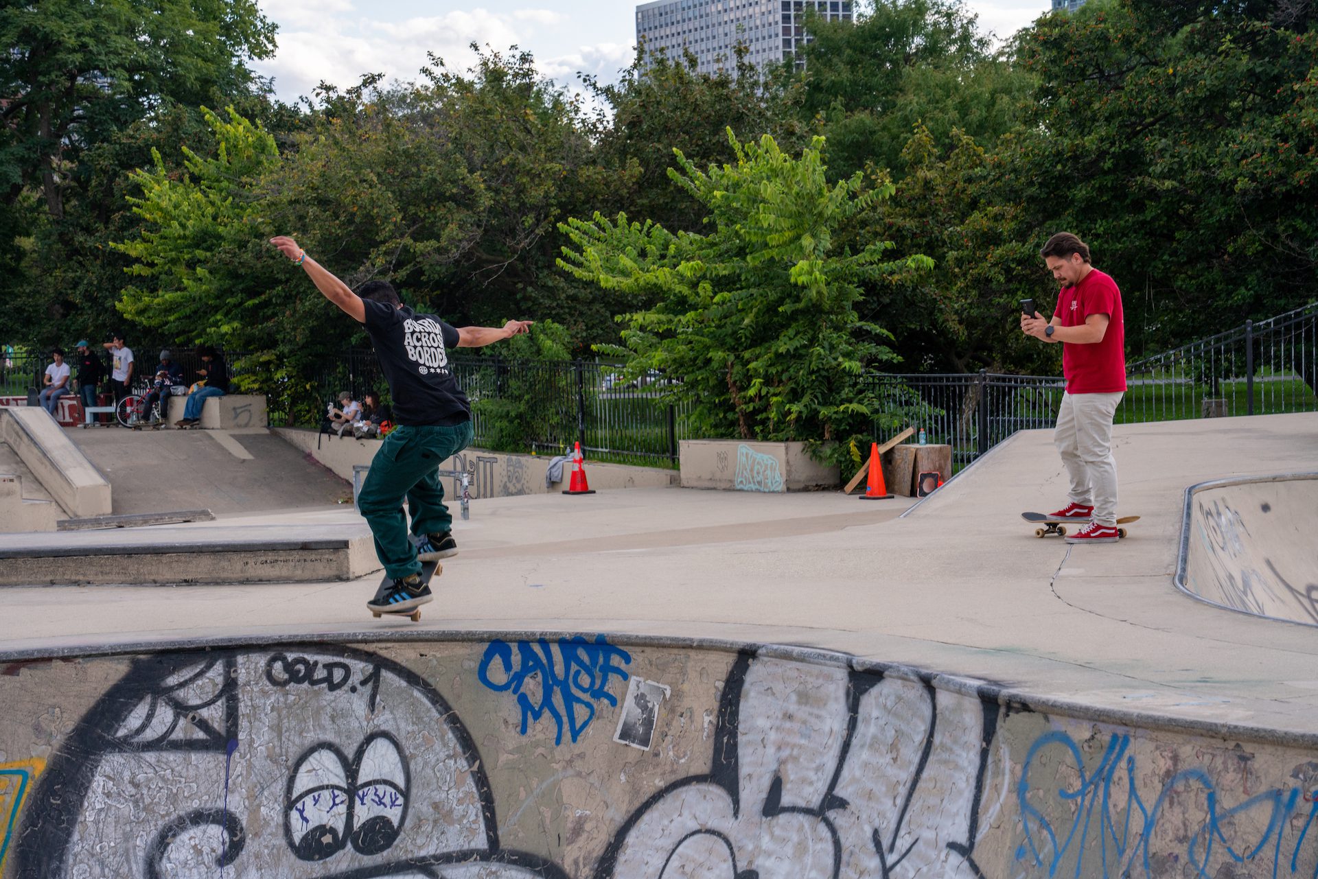 Javier Ponce skates a bowl back move with his arms stretched out at the Wilson Skate Park during a Boards across Borders fundraising event in partnership with Chicago Roller Girls.