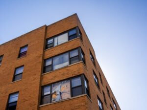 The corner of a multi-story apartment building is seen with broken, boarded-up windows. The South Shore apartment building was raided on Sept. 30 in the middle of the night by multiple federal agencies.