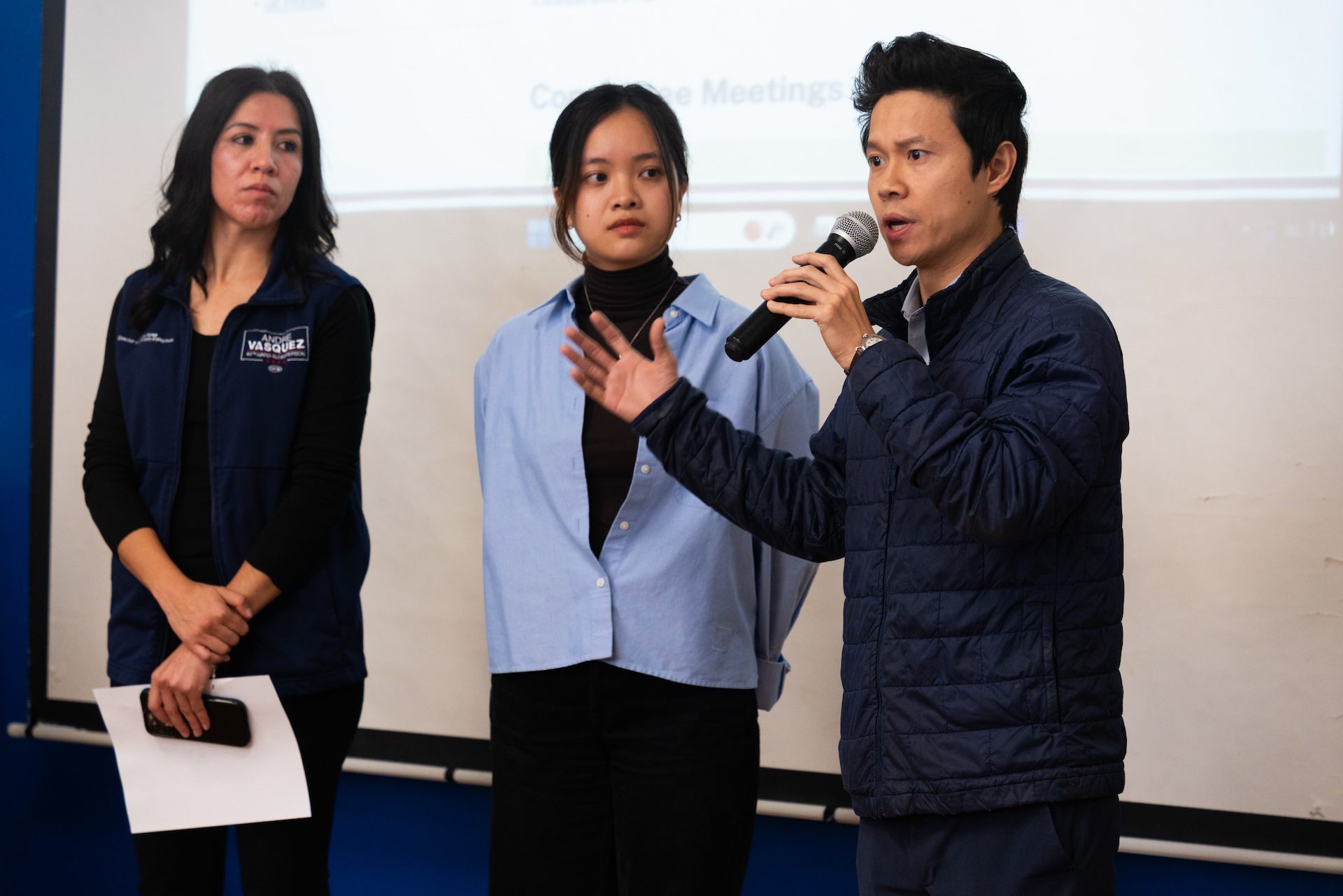 El Representante del Estado de Illinois Hoan Huynh se para con un micrófono frente a un grupo de propietarios de negocios durante un entrenamiento de Conozca sus Derechos para Negocios Locales en Uptown el martes 21 de octubre de 2025.