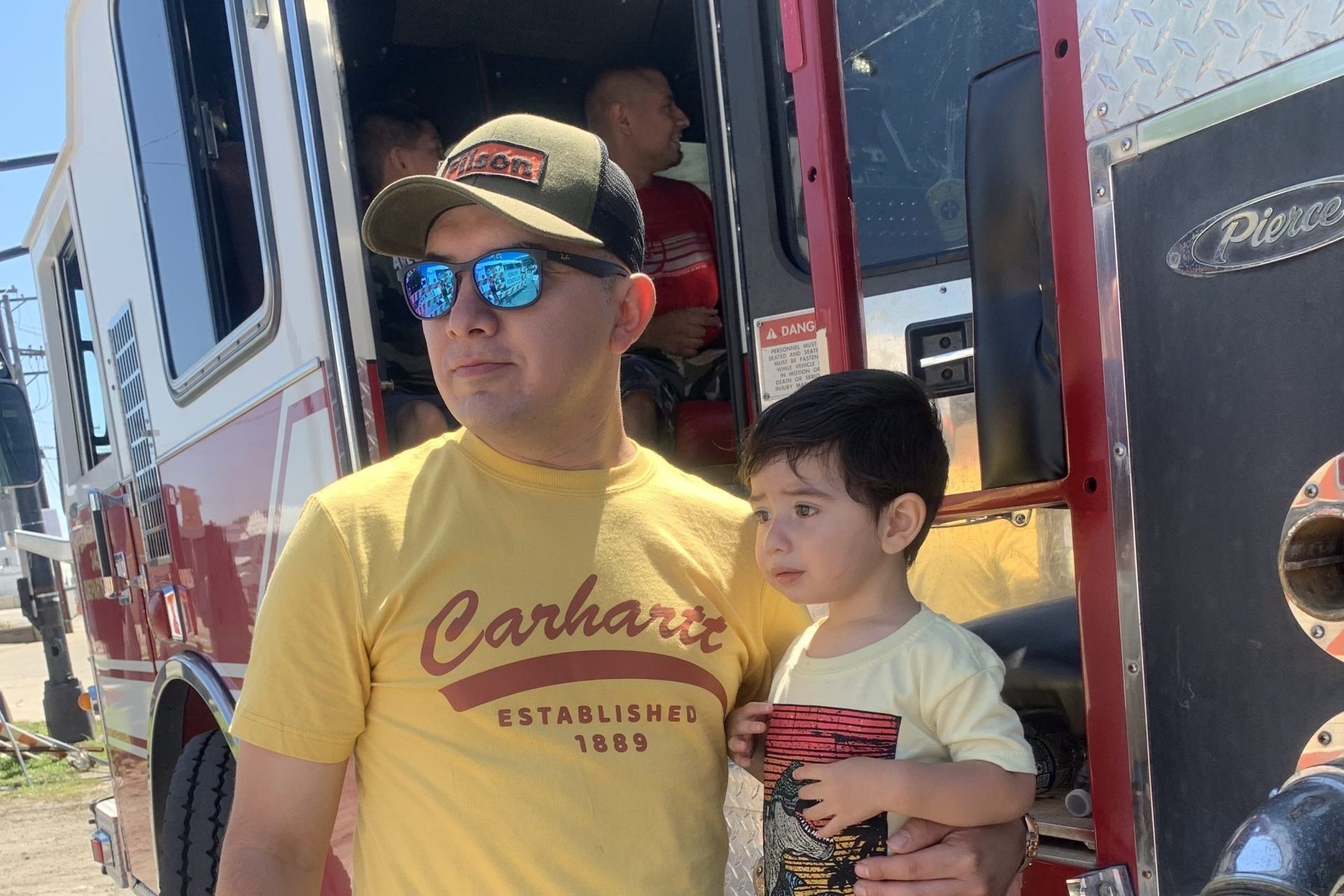 Ruben Torres Maldonado holds his son, Nathan outside of an open firetruck.