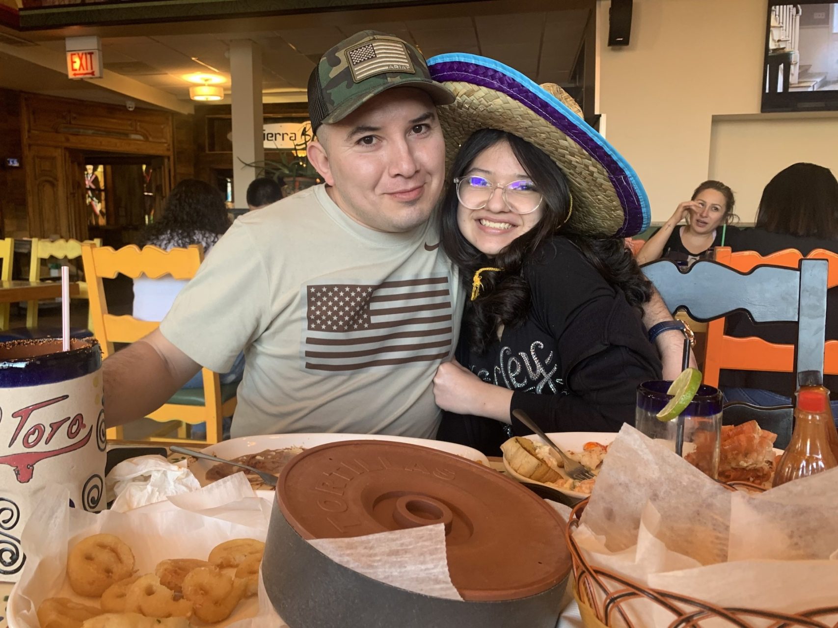 Rubén Torres Maldonado posa para una foto con su hija de 16 años mientras come en un restaurante.