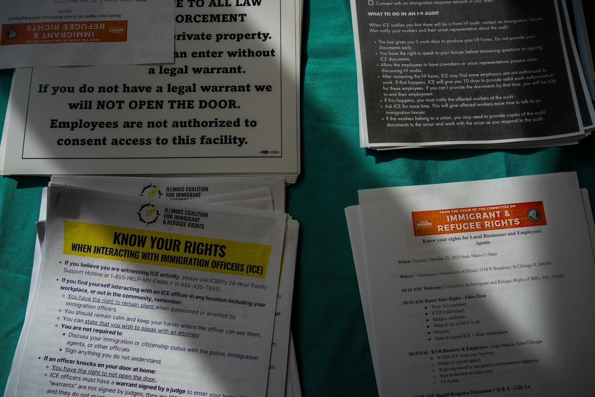 Four stacks of informational materials and private property signs are laid out during a "Know Your Rights" training for business owners in Uptown on Oct. 21, 2025.