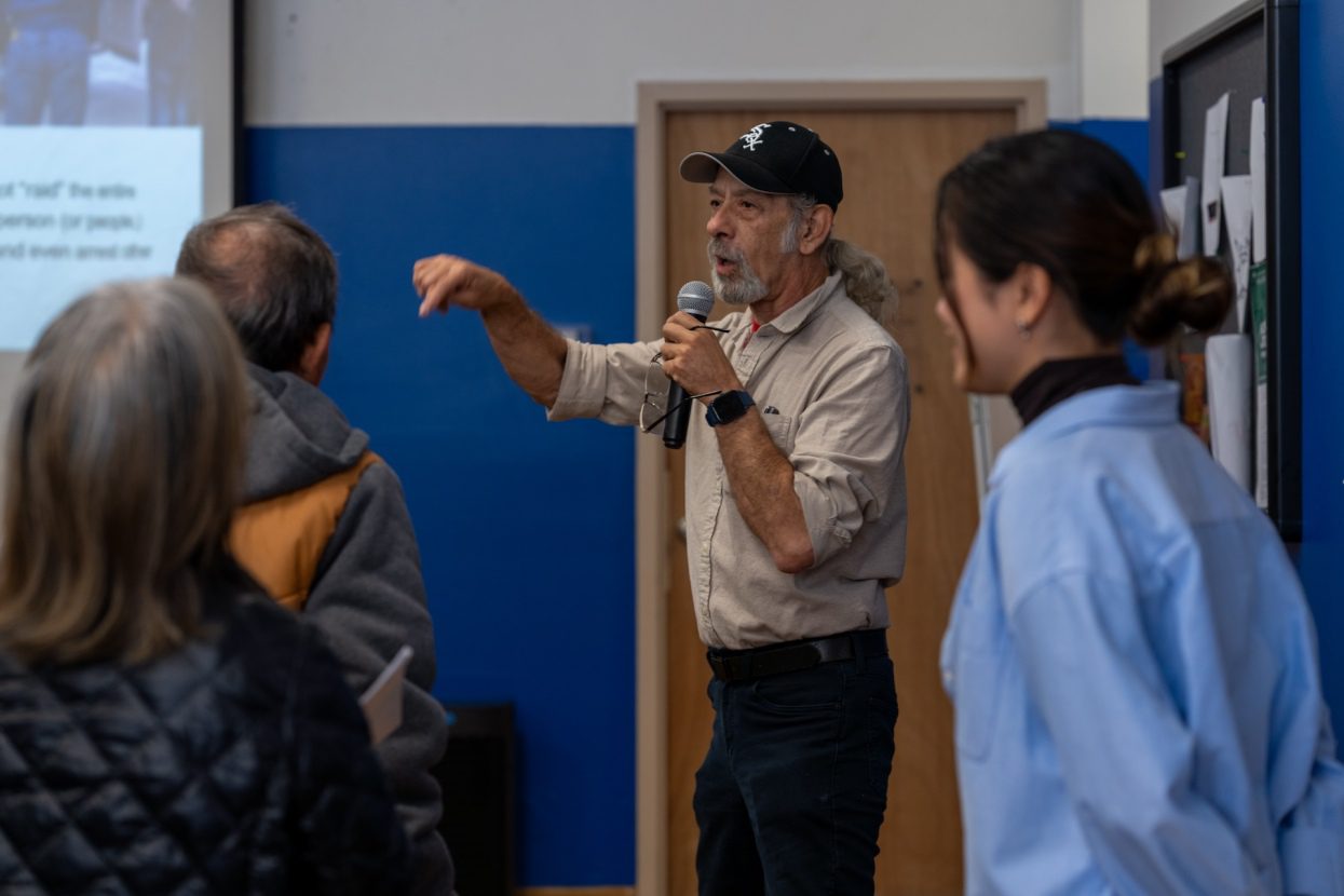 Jorge Mújica Murias, an organizer with Arise Chicago, stands in the front of a small meeting room as he walks small business owners through role play-scenarios to prepare them in case they encounter ICE officers on Oct. 21, 2025.