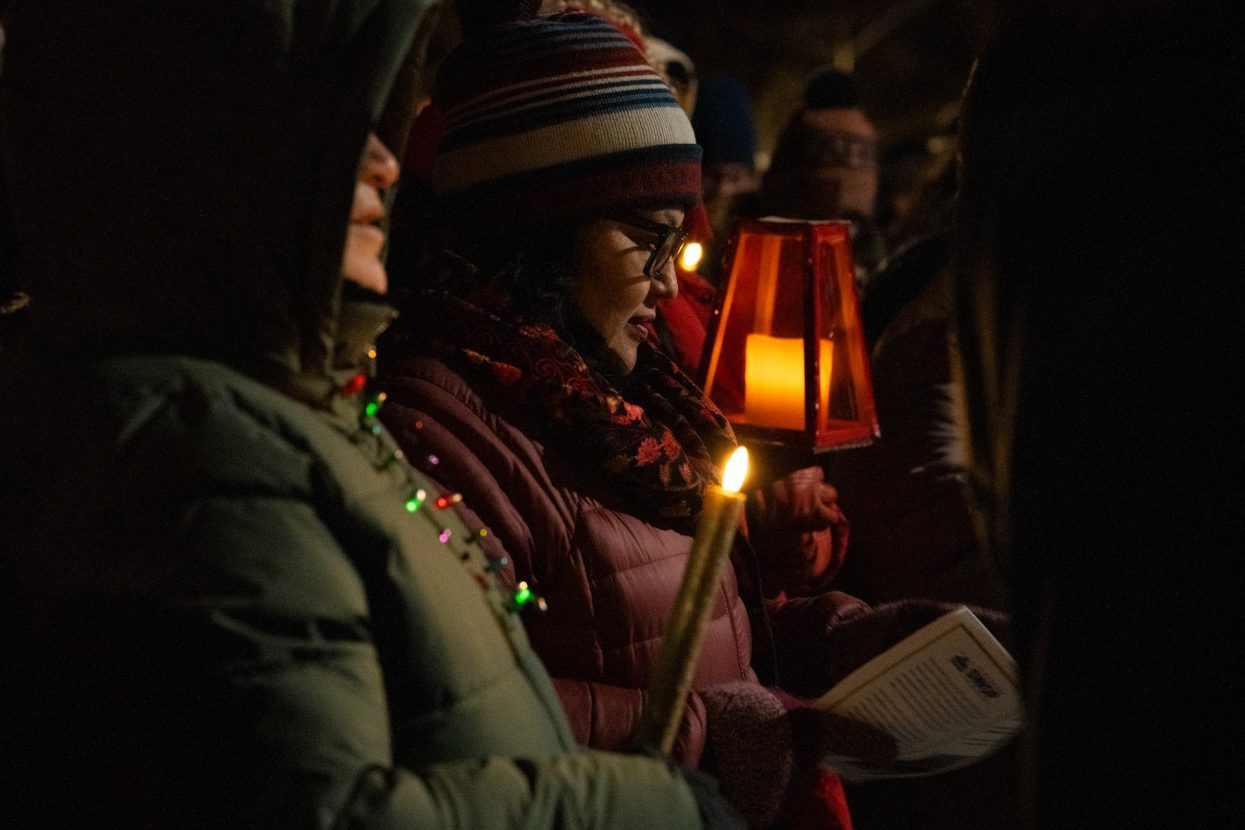 Ismelda Salazar, organizadora de South West Organizing Project (SWOP), es vista afuera en la noche mientras canta por alojamiento durante una recreación de posada en Oak Park el 19 de diciembre de 2025.