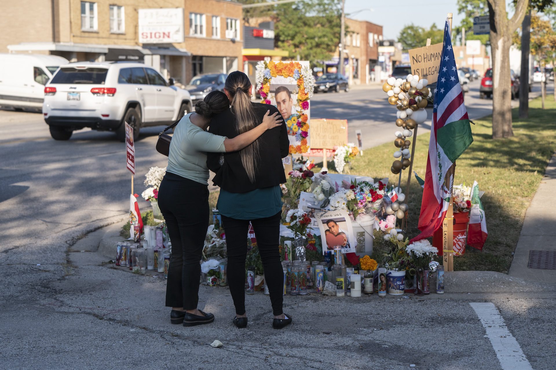 Elizabeth Diaz and Yadira Nevarez hold each other as they visit a vigil near the scene of the fatal shooting of Silverio Villegas-Gonzalez along Grand Avenue, near a bank where they work, in Franklin Park, IL, on Wednesday, Sept 17, 2025.