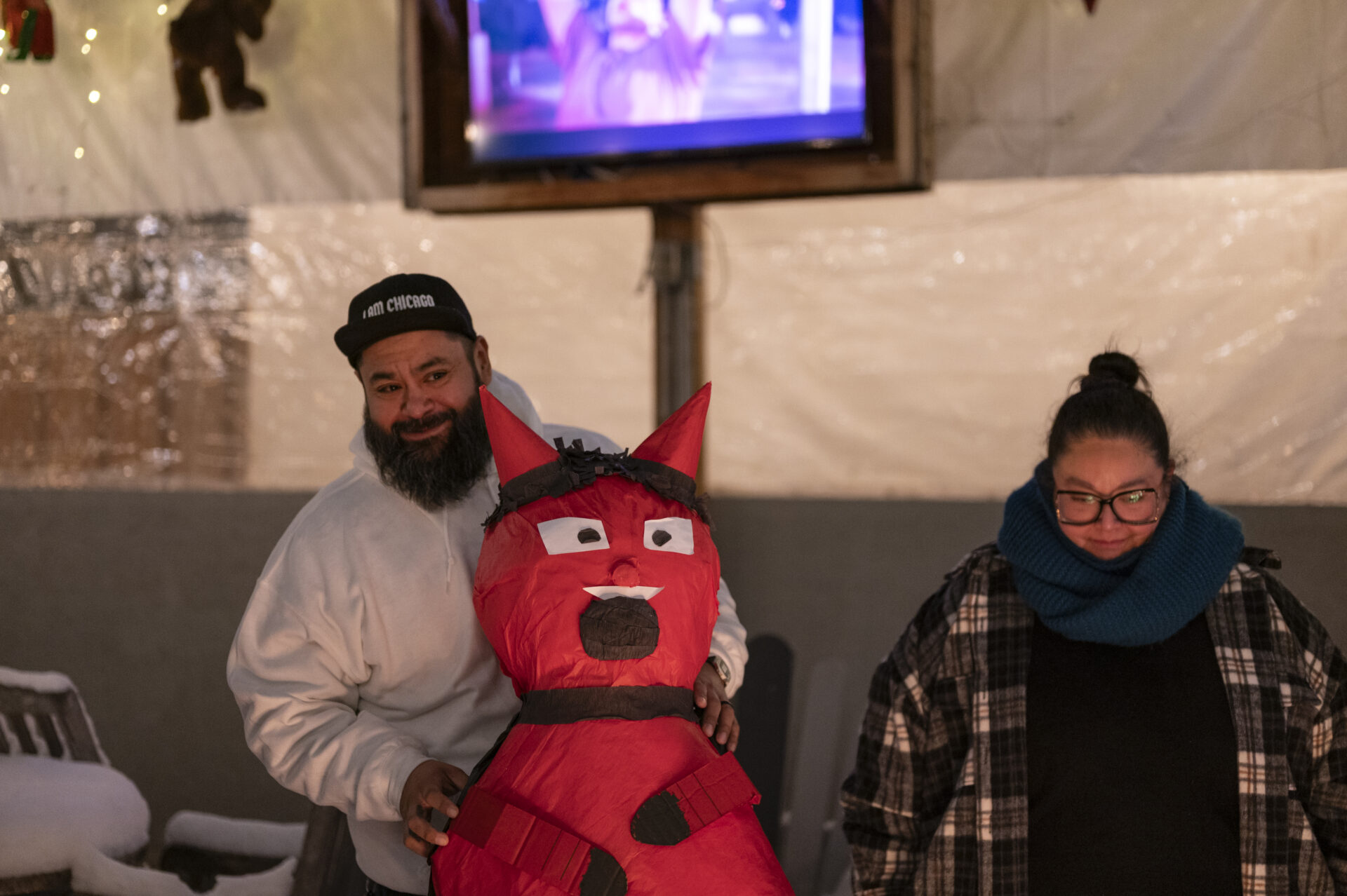 Manuel Girón smiles as he prepares to drop a large devil piñata into the fire pit at Park & Field in the Logan Square neighborhood of Chicago.