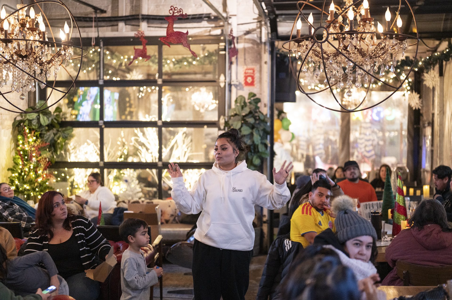 Valeska Girón, seen inside the spacious Park & Field bar, directs people with her hands and voice outside of the bar to the patio for the beginning of the burning of the devil and notes.