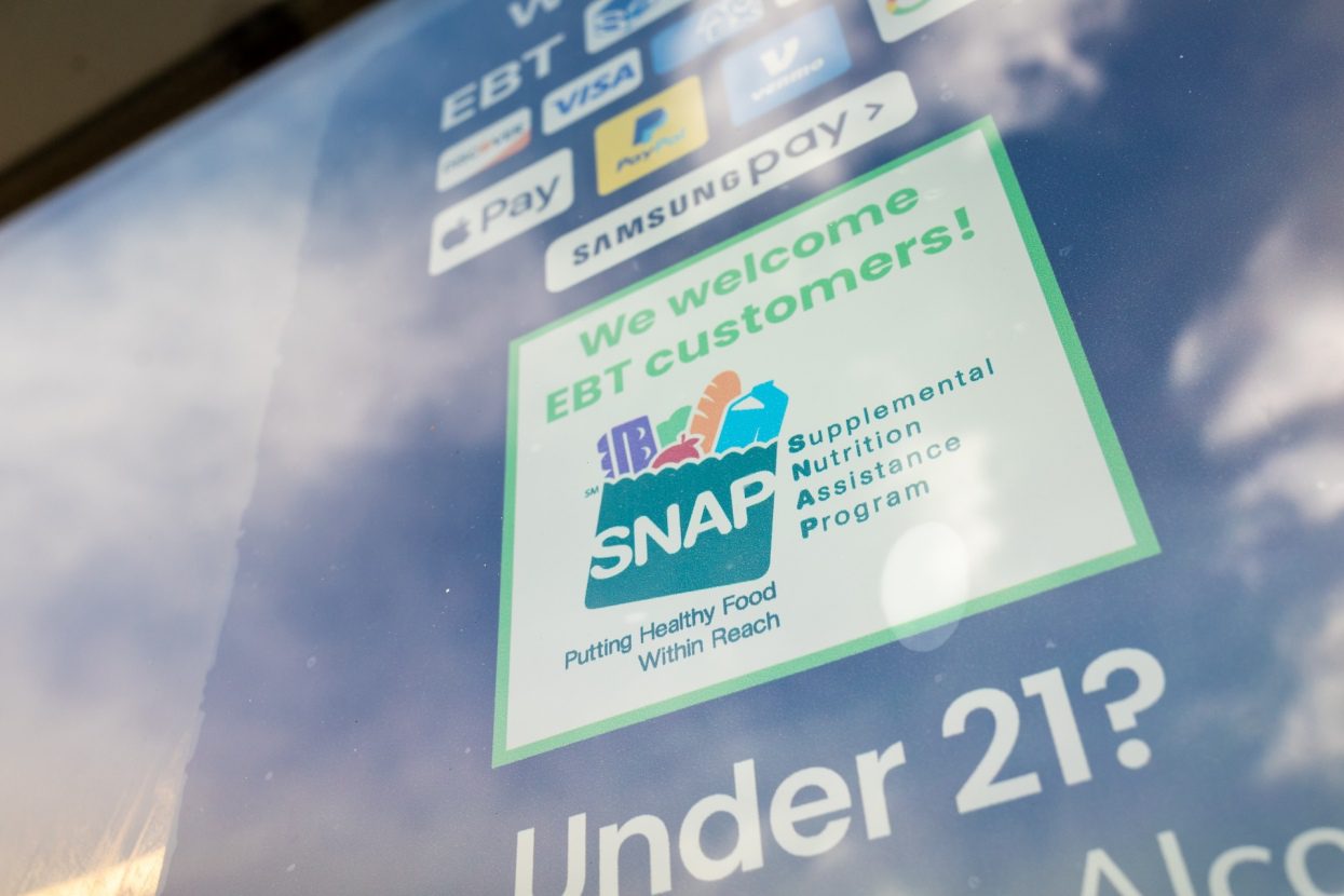 A sign on a grocery store displays that they accept Supplemental Nutrition Assistance Program (SNAP) benefits.