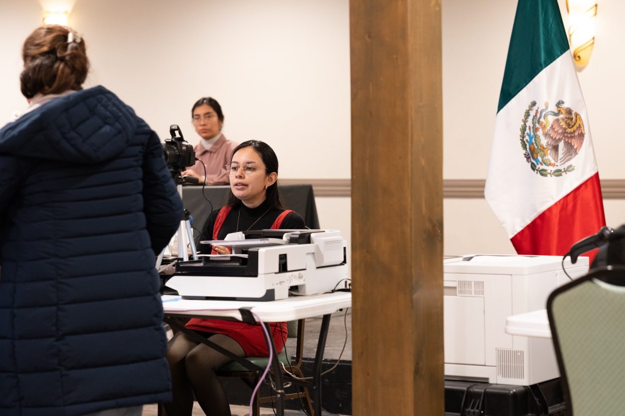 A consulate worker helps a client a pop up in the Chicago suburbs as part of the Mexican Consulate's “Consulado Sobre Ruedas initiative.”