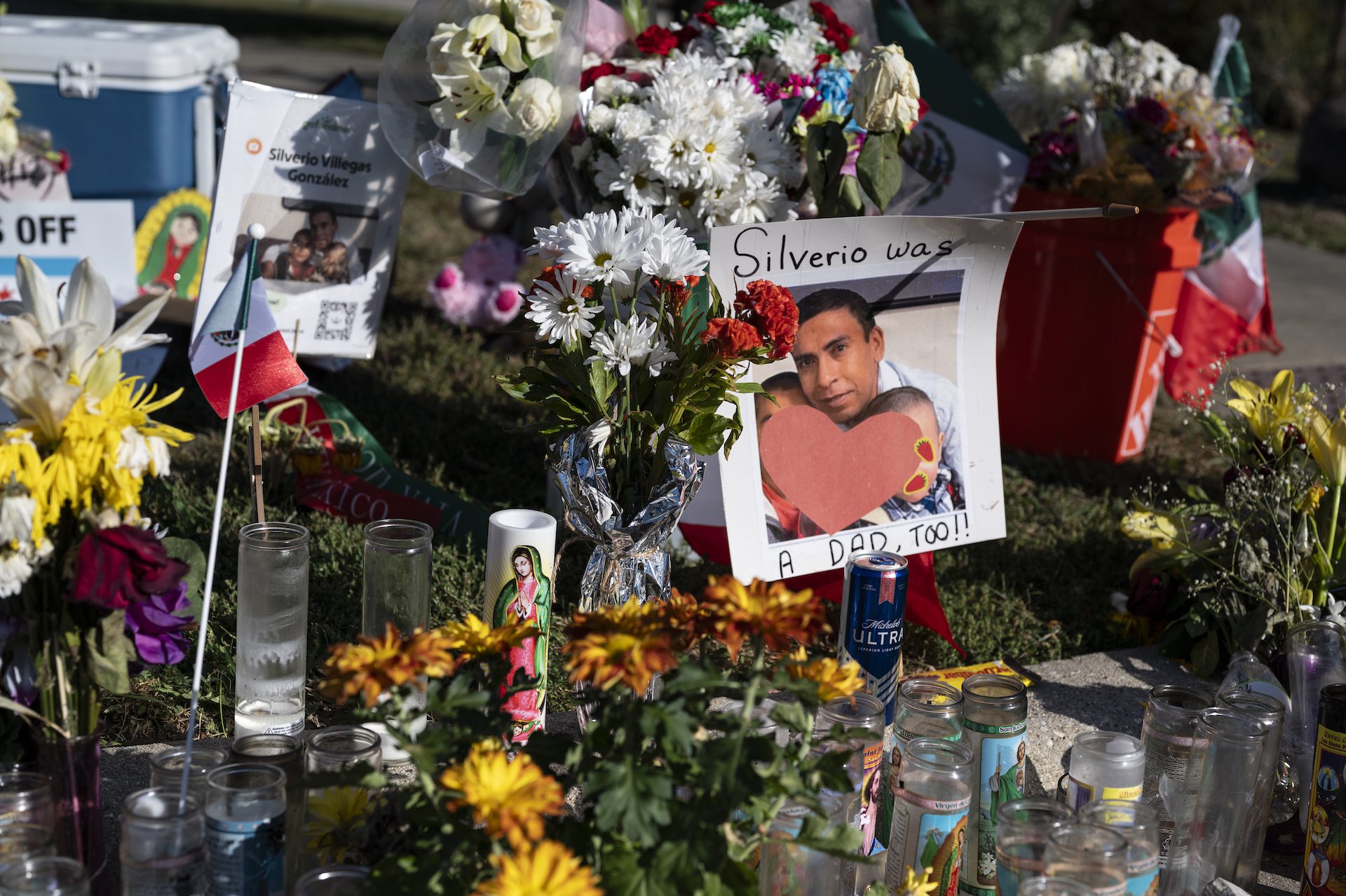 Flowers, candles, and signs make up a vigil for Silverio Villeges-González in Franklin Park.