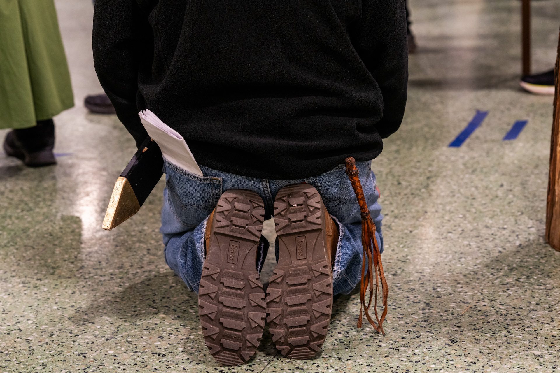 An actor, with a sword on one hip and a whip on another, kneels in prayer during a rehearsal for Pilsen’s Via Crucis procession.