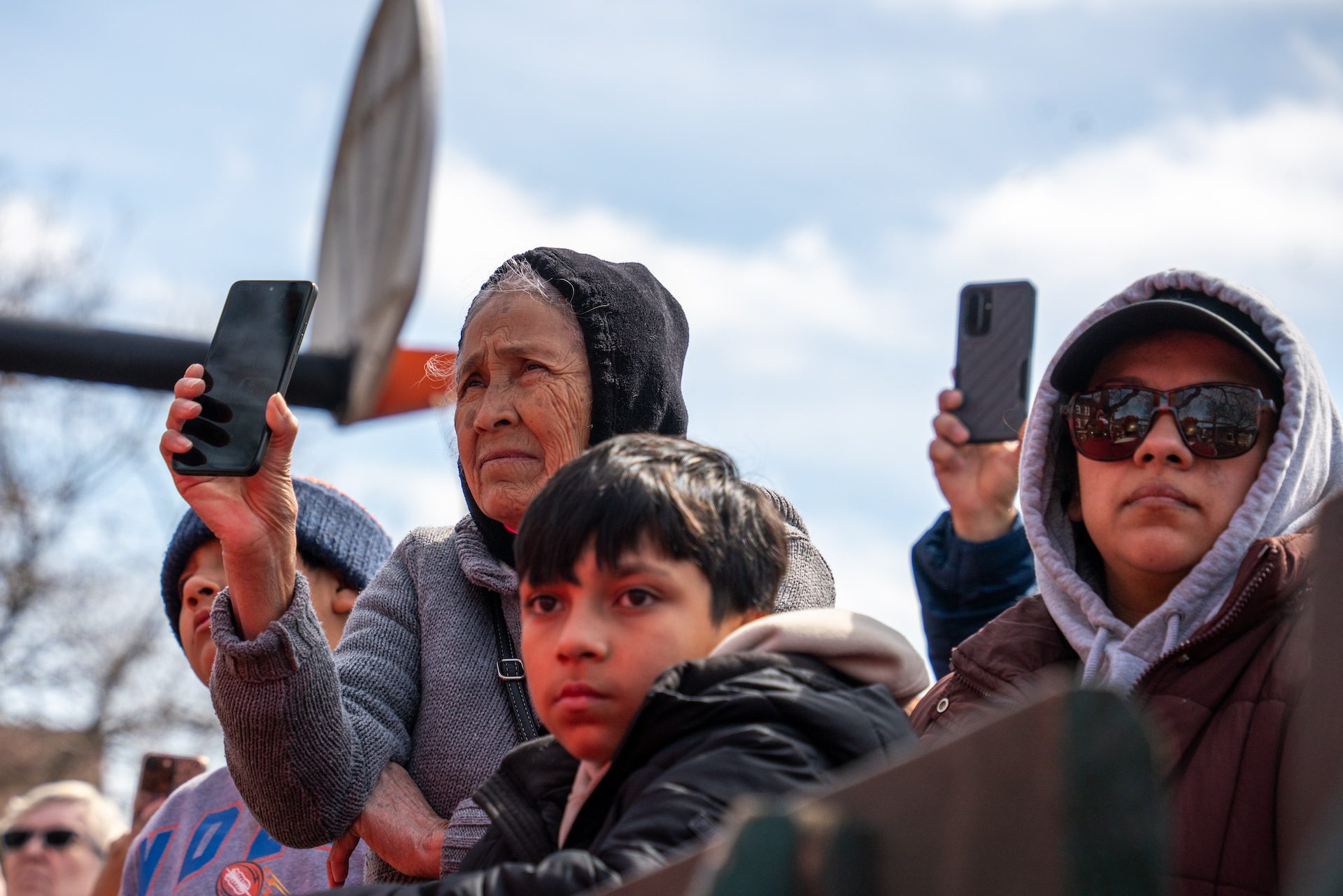 A child and older women watch the crucifixion of Christ in Harrison Park at the Via Crucis procession along 18th Street in Pilsen.