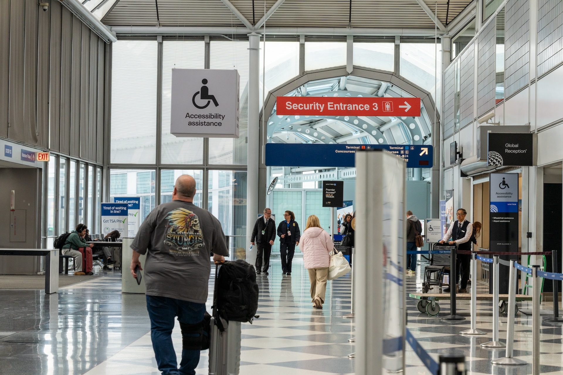 Travelers walk towards a security screening at Chicago O'Hare airport.