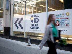Real ID signage covers an office building as a woman walks past.