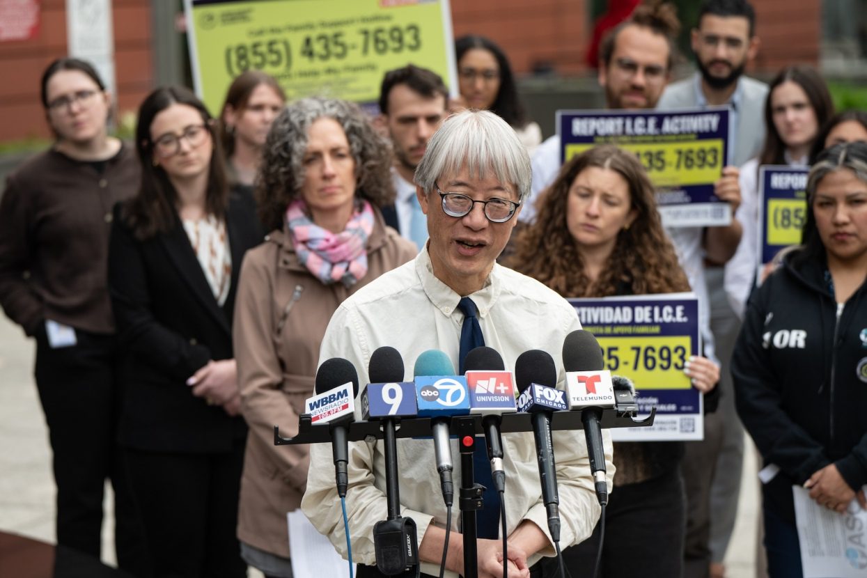 Fred Tsao with the Illinois Coalition for Immigrant and Refugee Rights (ICIRR) stands in front of a large group of advocates outside the Cook County Domestic Violence Courthouse during a press conference.