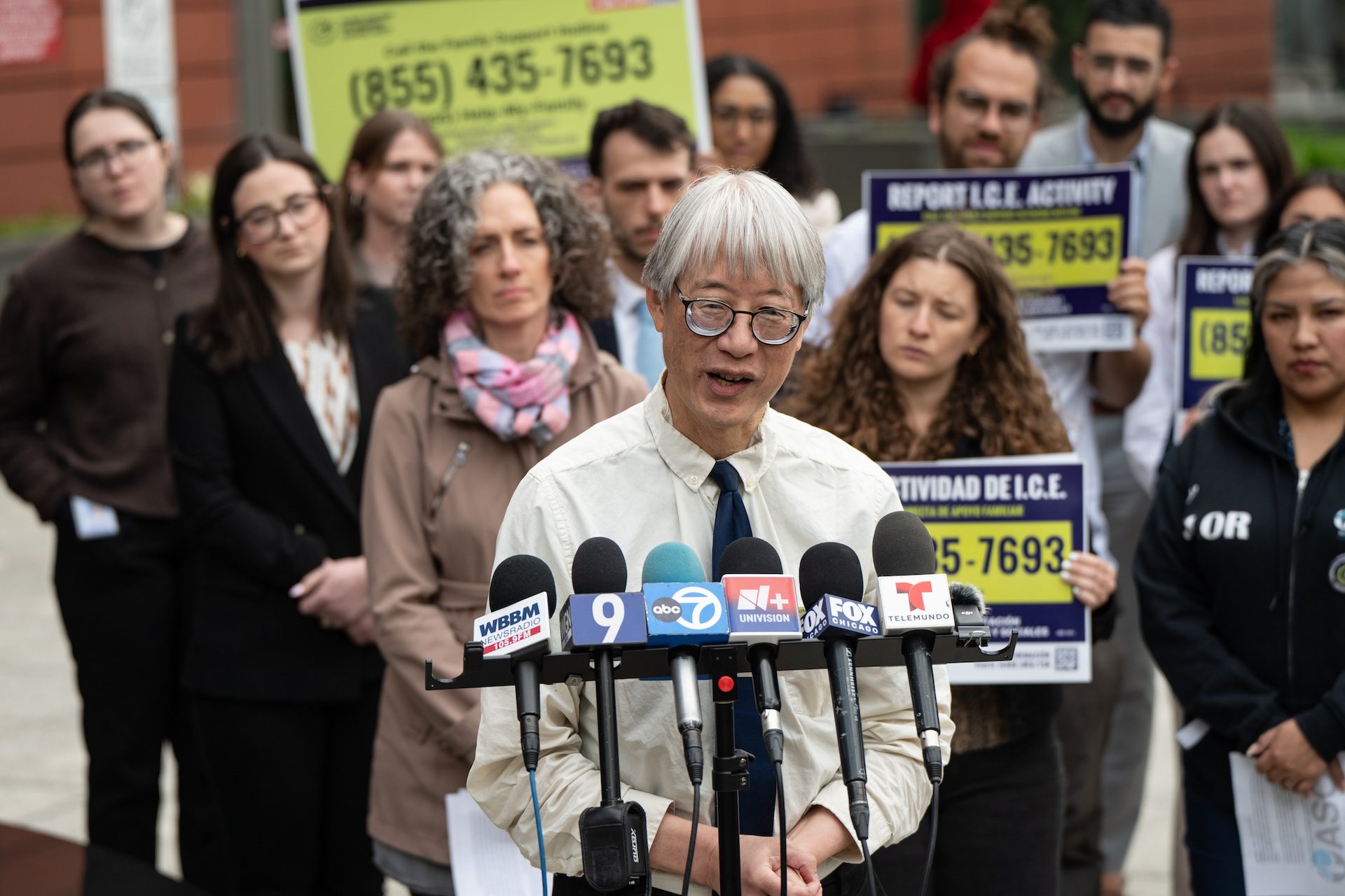 Fred Tsao with the Illinois Coalition for Immigrant and Refugee Rights (ICIRR) stands in front of a large group of advocates outside the Cook County Domestic Violence Courthouse during a press conference.