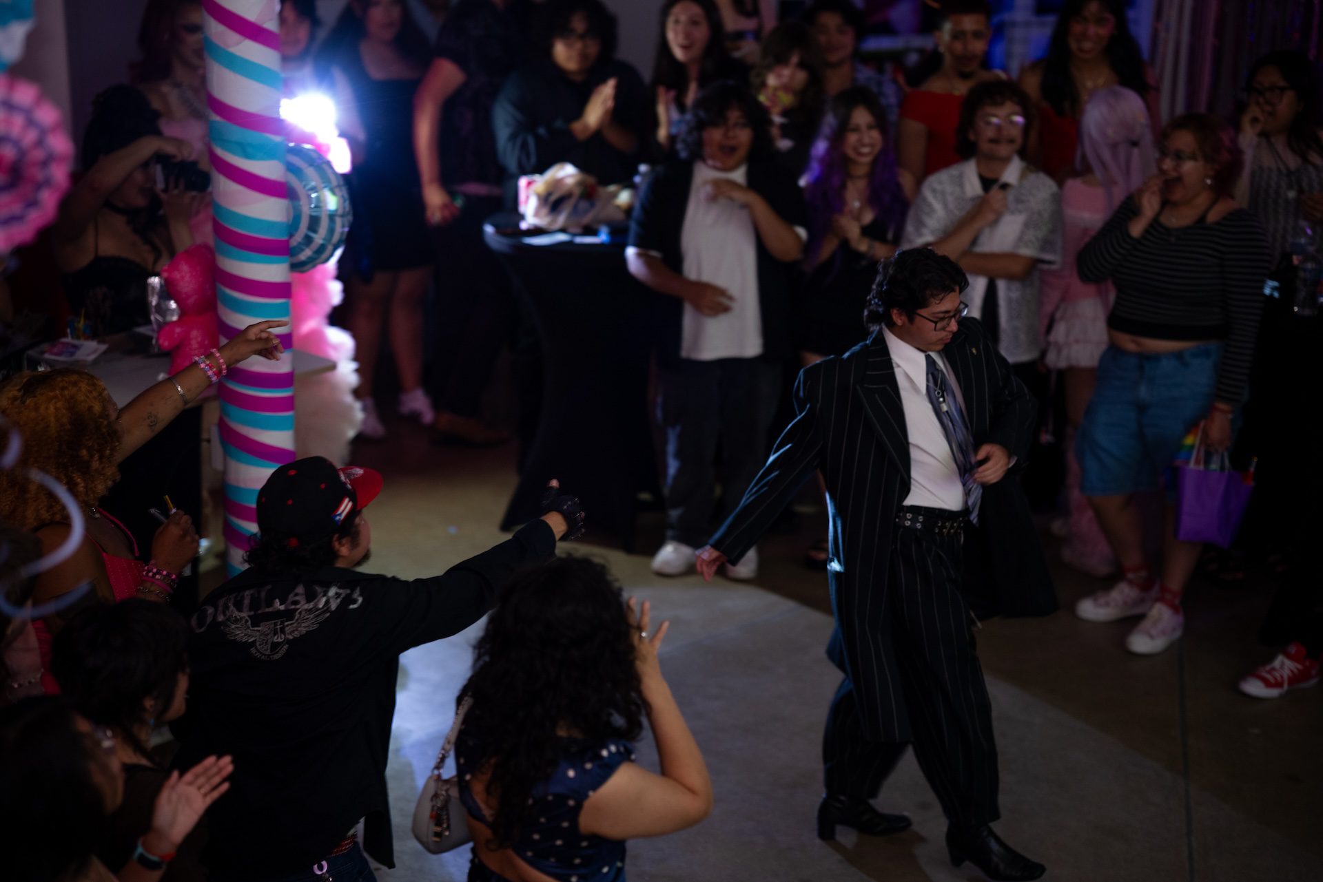 Macario Meza wears a suite as he walks down the runway to cheers from the crowd after being nominated Prom King by attendees during Yoloccalli and CALOR’s queer prom.