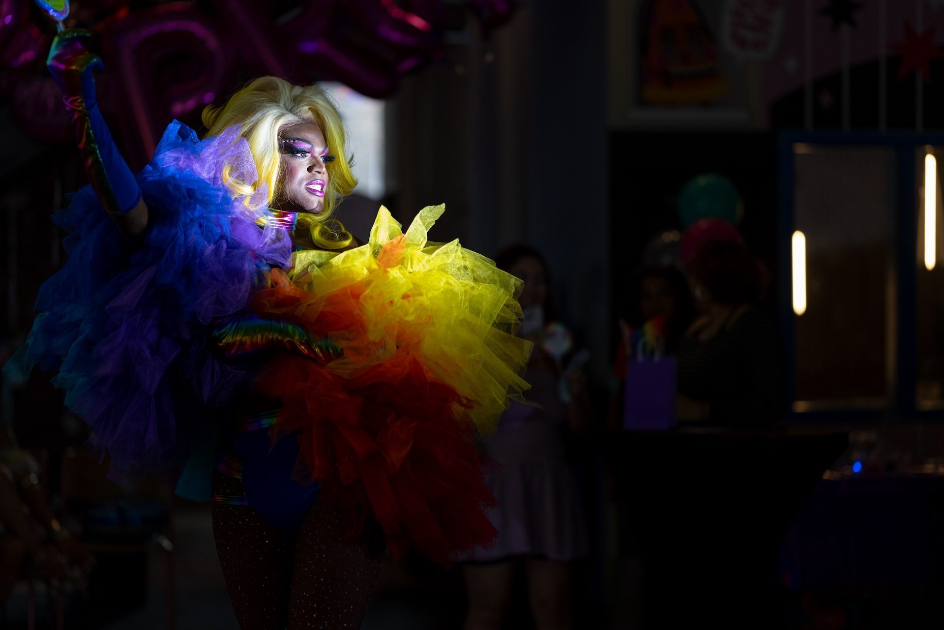 Drag queen Teyanna Traid, in a spotlight, makes a grand entrance to kick off her performance during Yollocalli and CALOR’s queer prom.