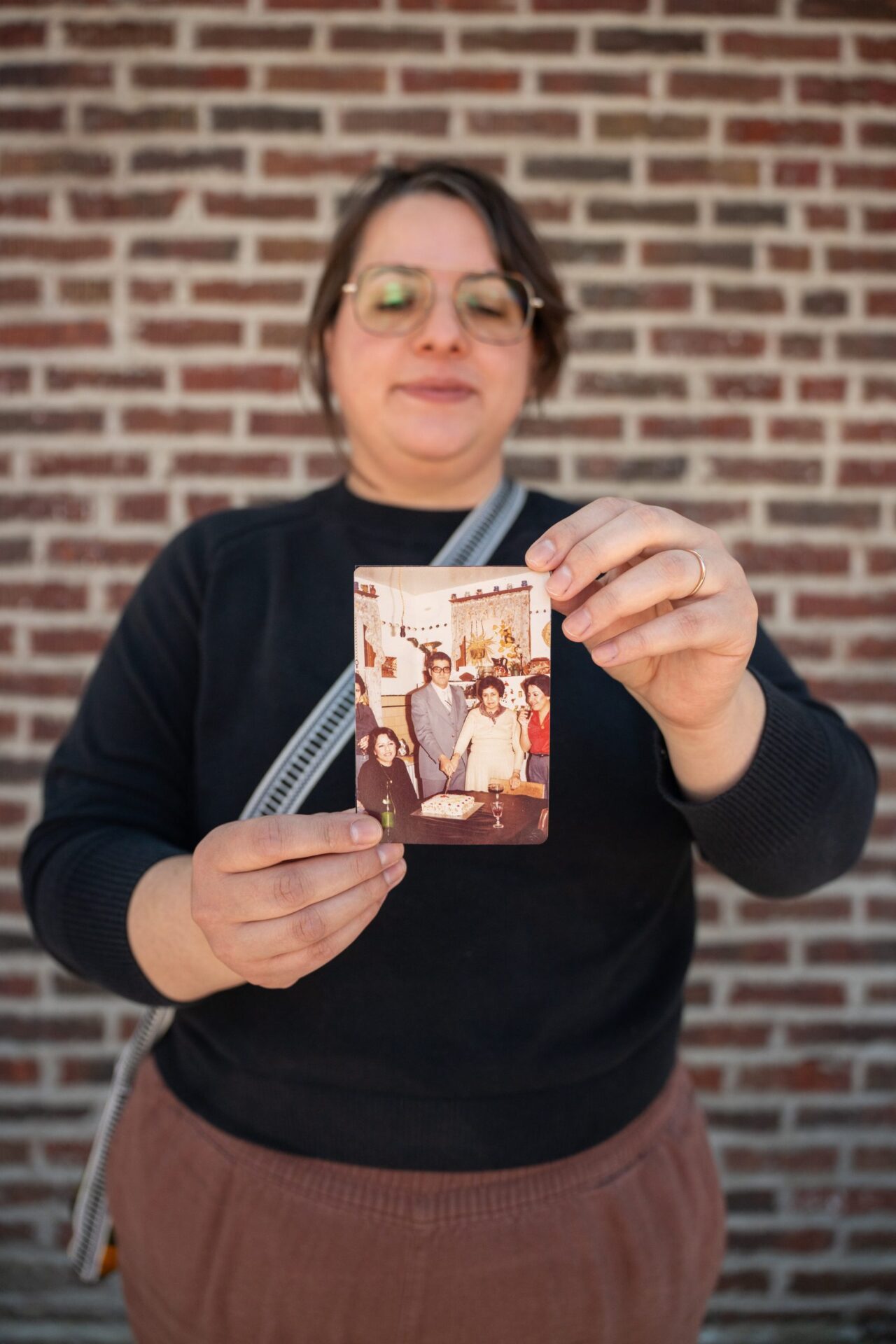 Melissa Chaidez stands outside holding a family photograph of her grandparents celebrating their 25th wedding anniversary in Little Village in 1982 on May 23, 2026.