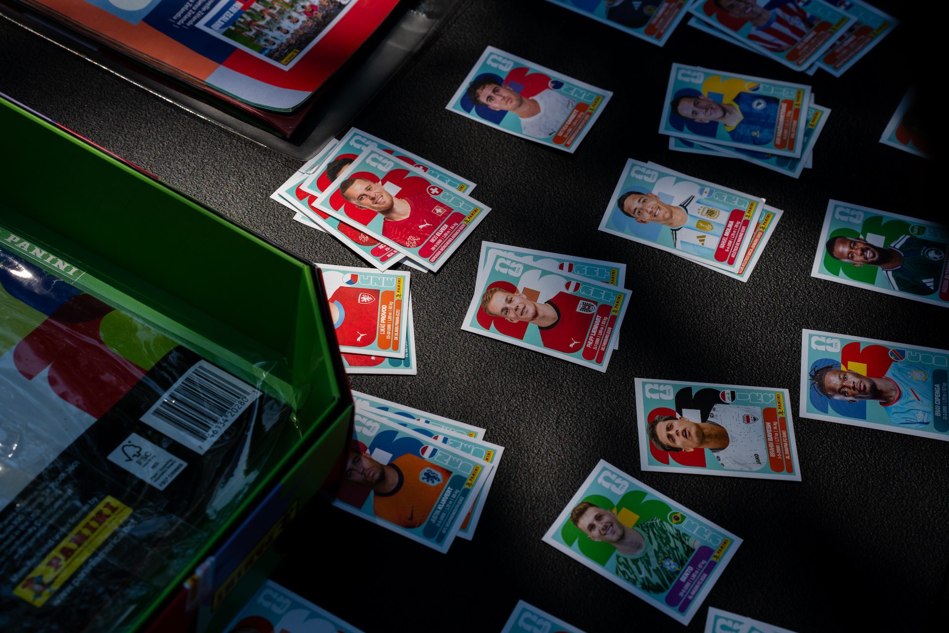 2026 Panini stickers are laid out in stacks at an outdoor sticker trading event in Portage Park.