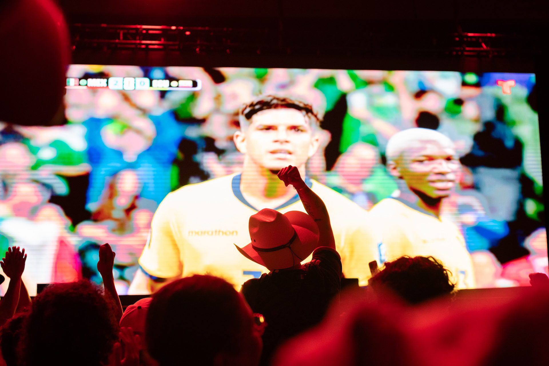 Mexico fans celebrate in front of a large projection screen after the Mexican team scores their second goal against Ecuador.