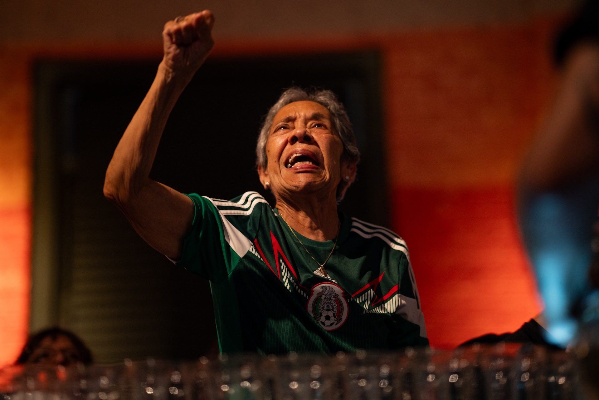 A spectator raises their first as they celebrate Mexico winning against S. Korea during the World Cup.