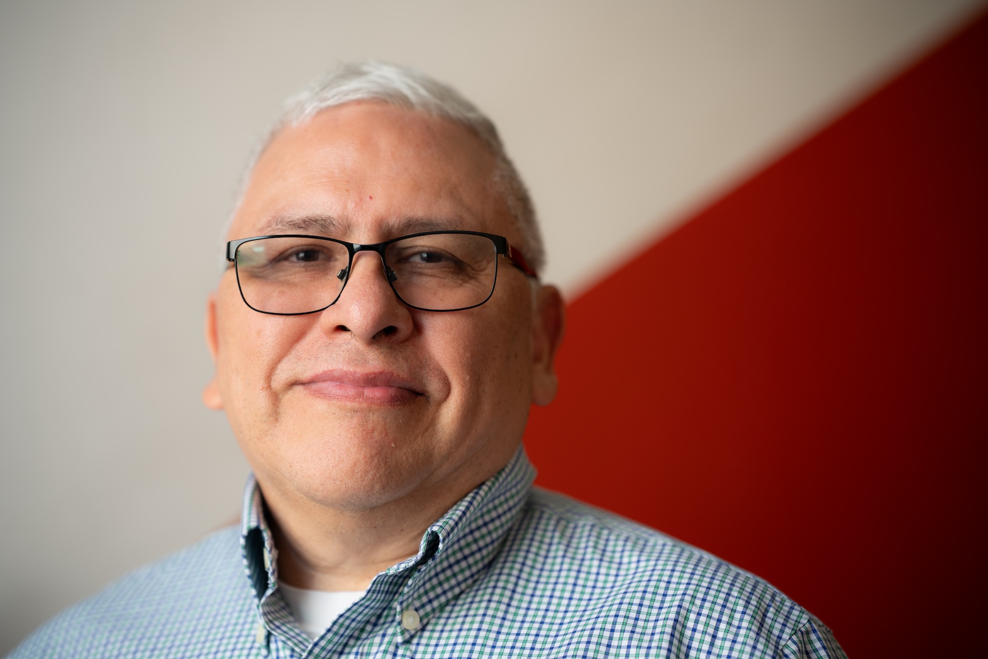 Jose Mosqueda, Adult Education Programs Manager at Erie Neighborhood House, smiles as he poses for a photo at Erie Neighborhood House.