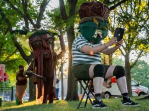 Actor Dre Meza plays an acorn character with a large mask during Free Street's debut performance of "Touch Grass" at Davis Square Park in the Back of the Yards neighborhood.
