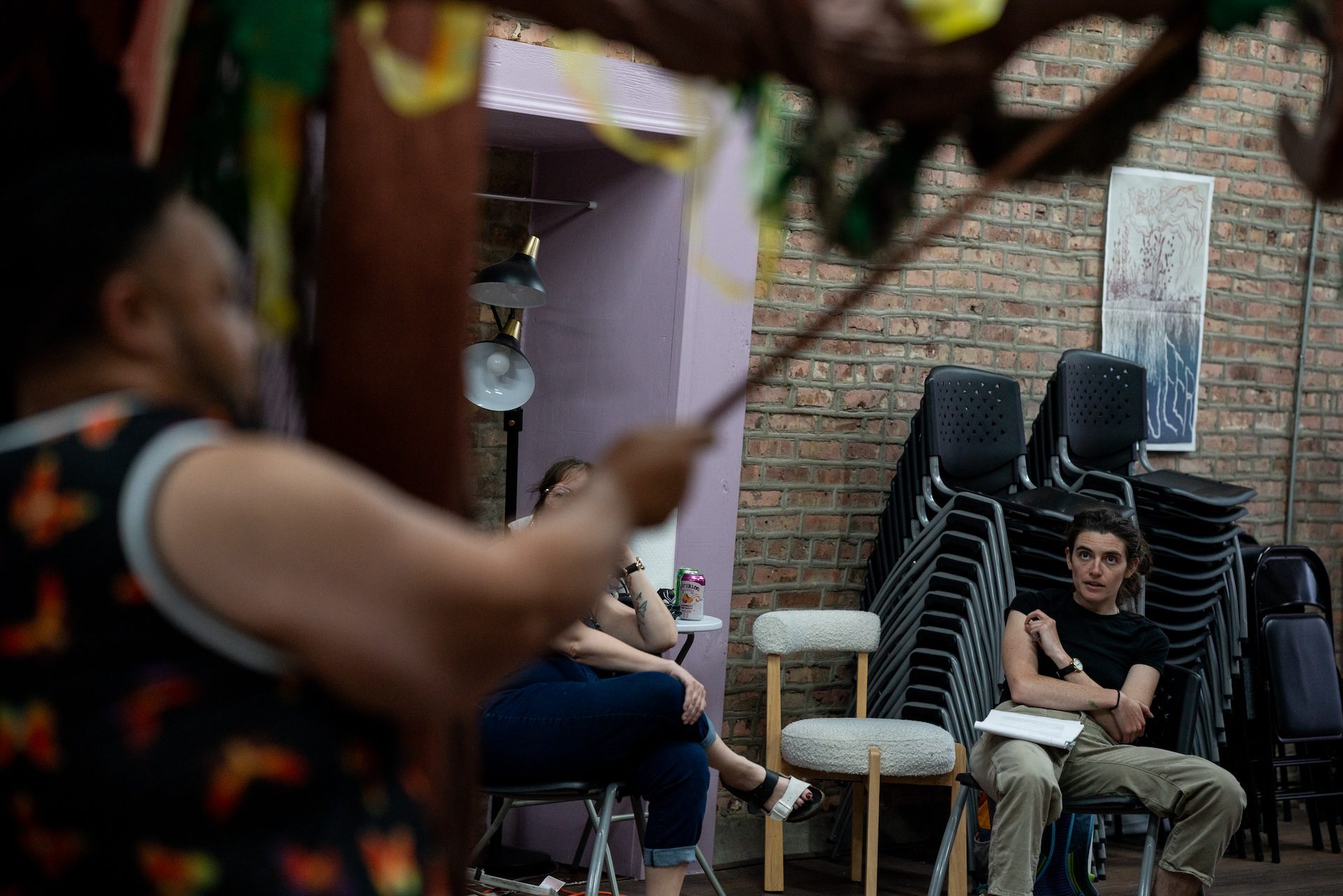 Co-Director Sivan Spector, seated, gives performers a note on how to best move together as tree elder during dress rehearsal at Free Street Theater’s storefront location in Back of The Yards on July 10, 2026.