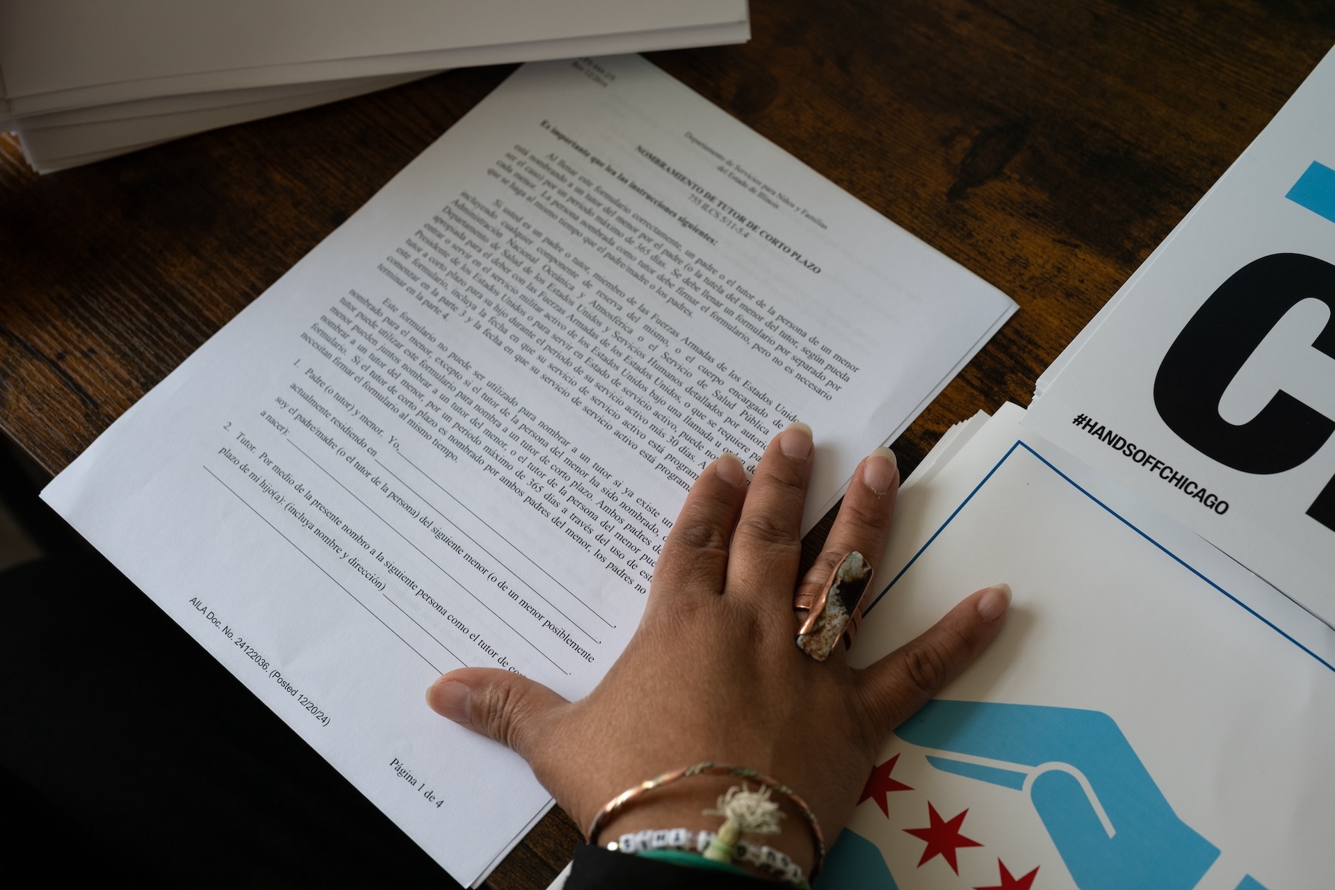 Maritza places her hand on forms and signs handed out by rapid responders and multiple organizations.