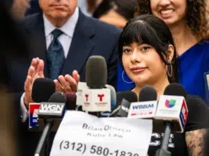 Dayanne Figueroa speaks as elected officials, attorneys, community leaders, and victims from Operation Midway Blitz hold a press conference on Aug. 10, 2026 outside the Chicago Police Department at 2452 W. Belmont Ave. in North Center ahead of filing police reports with the Chicago Police Department that allege crimes committed by ICE agents.
