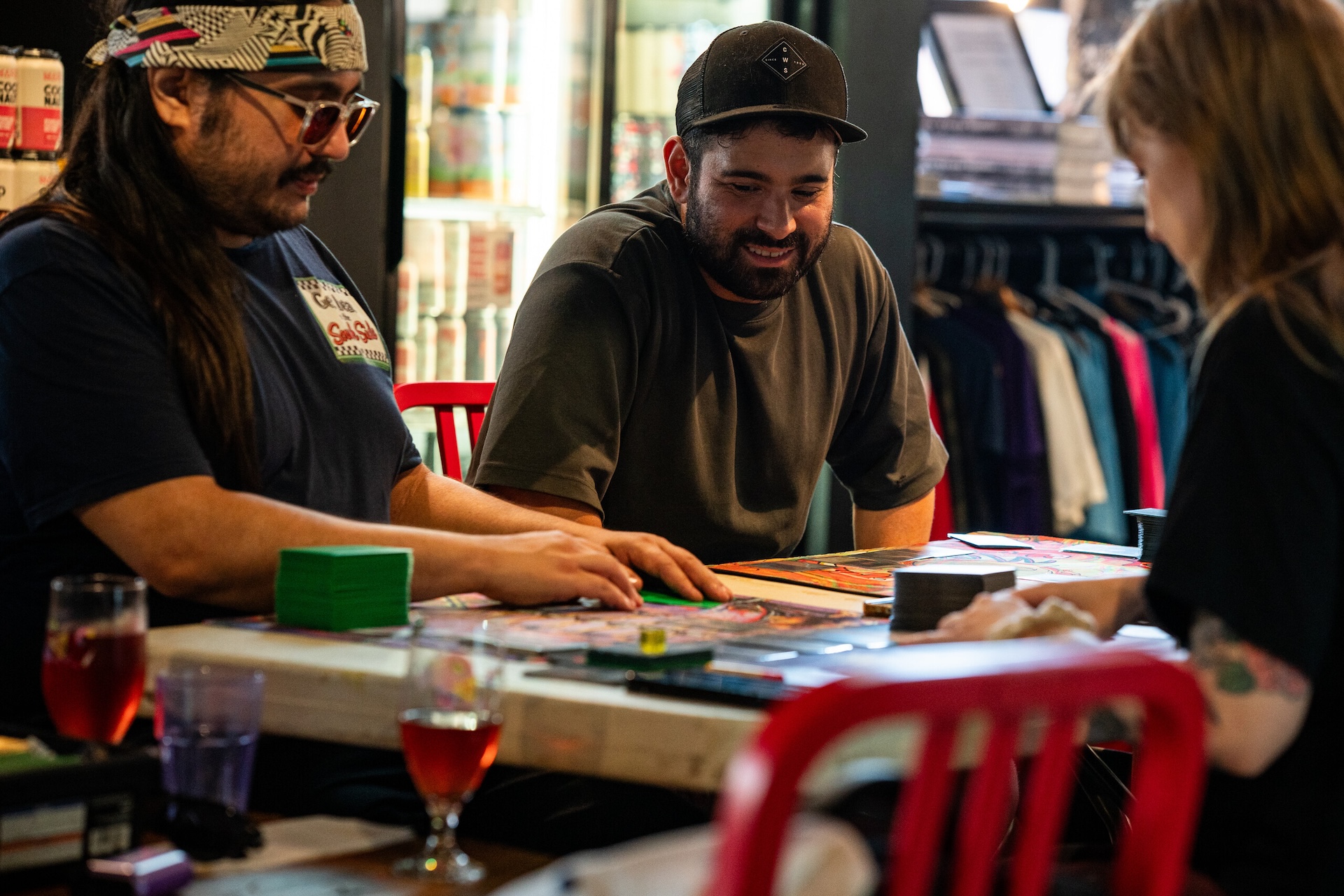 Atticus Aguirre smiles as he plays Magic: The Gathering with friends at a table during Marz Community Brewing’s game night on July 30, 2026.