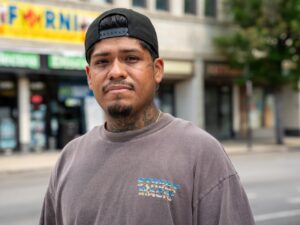 Brian Nazario, stands on Lawrence avenue, in the neighborhood where he grew up, Albany Park.