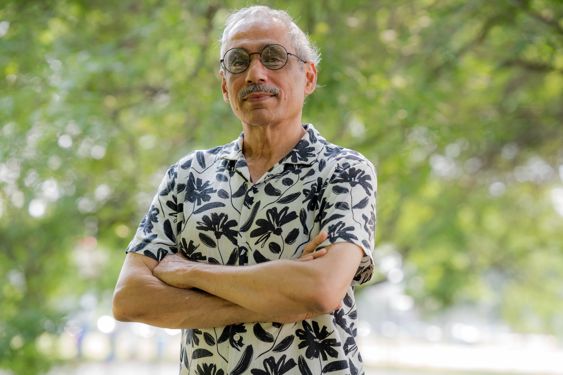 Community organizer Baraht Sharma stands for a portrait with his arms crossed in West Ridge’s Warren Park.