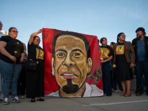 Organizers with Hijas del Pueblo, Casa Du Page and the Resurrection Project hold up a large painted portrait of Silverio Villegas González on canvas outside the Franklin Park Police Department at 9451 W. Belmont Ave. on Aug. 17, 2026.