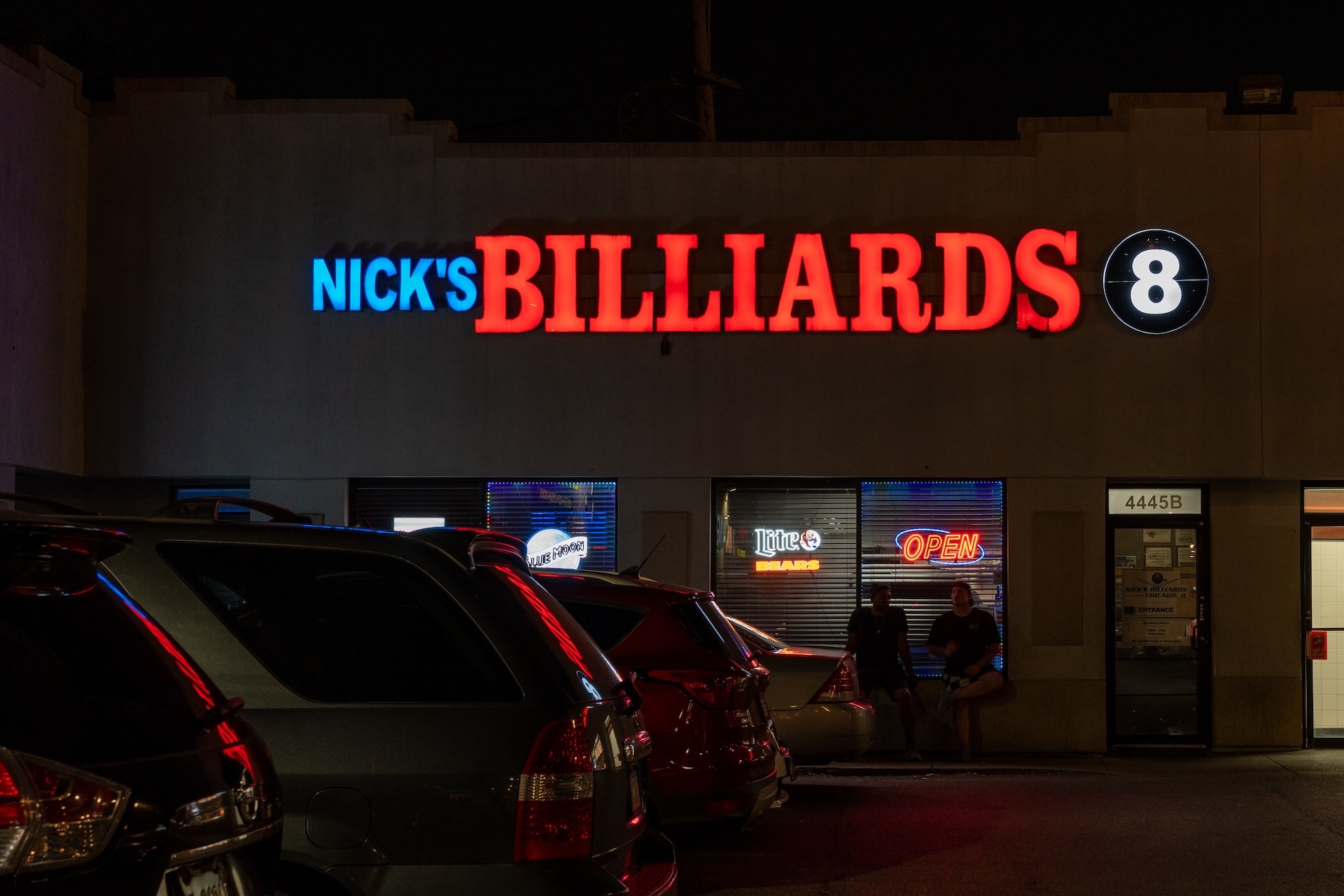 Two pool players sit outside at night as they take a smoke break at Nick’s Billiards Academy in Albany Park.