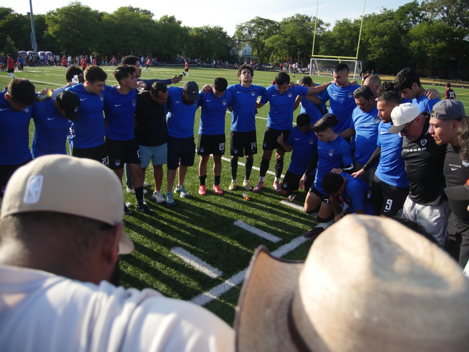 Over a dozen players on the Atlético Nacional team hold each other while in a huddle with supporters after securing their spot in the Division A final on September 6, 2026.