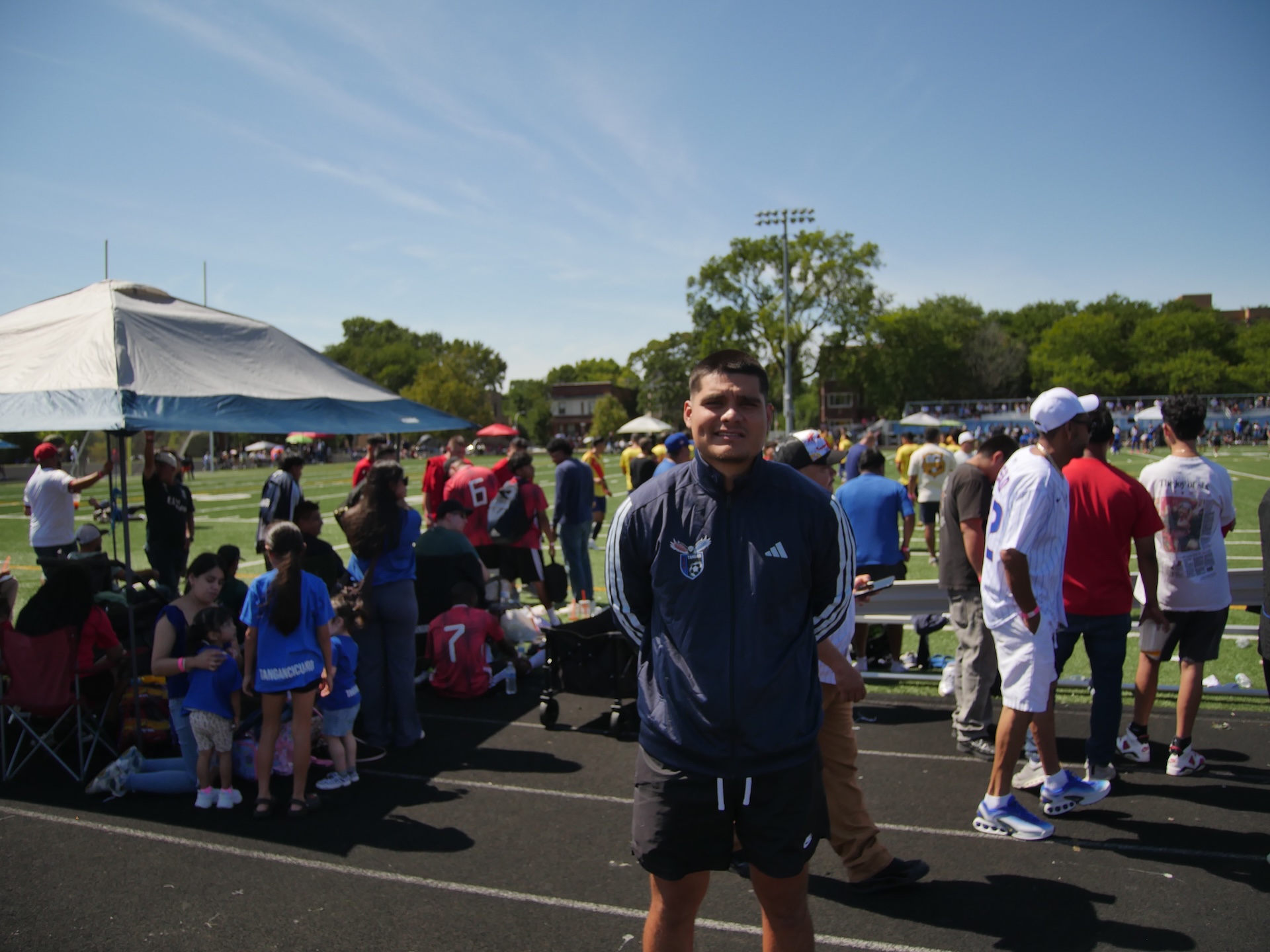 Jaime Alonso standing on a running track near a soccer field and his family’s tent just after his team’s win vs. Celaya F.C. on September 6, 2026 at Englewood STEM High School.