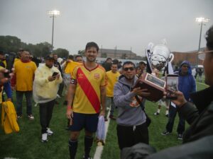 On a rainy day, Lorenzo Espinoza (left) presents the trophy to Omar Ayala (right) after Morelia’s 2-0 win against Atlético Nacional on September 20, 2026.